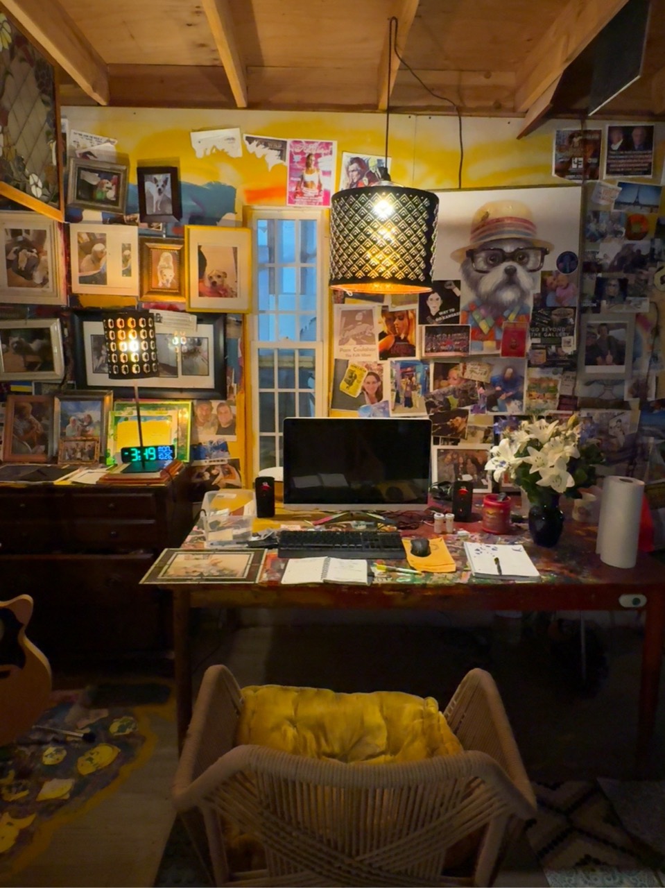 Bob’s workspace: his table, wicker chair and walls covered with photographs and keepsakes